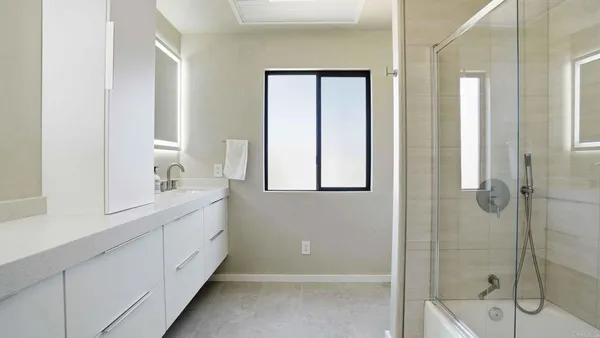 a en suite bathroom with a sink double vanity and mirror