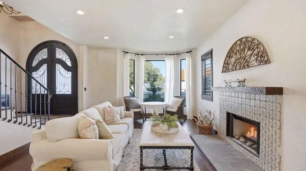 a living room with furniture a fireplace and a large window