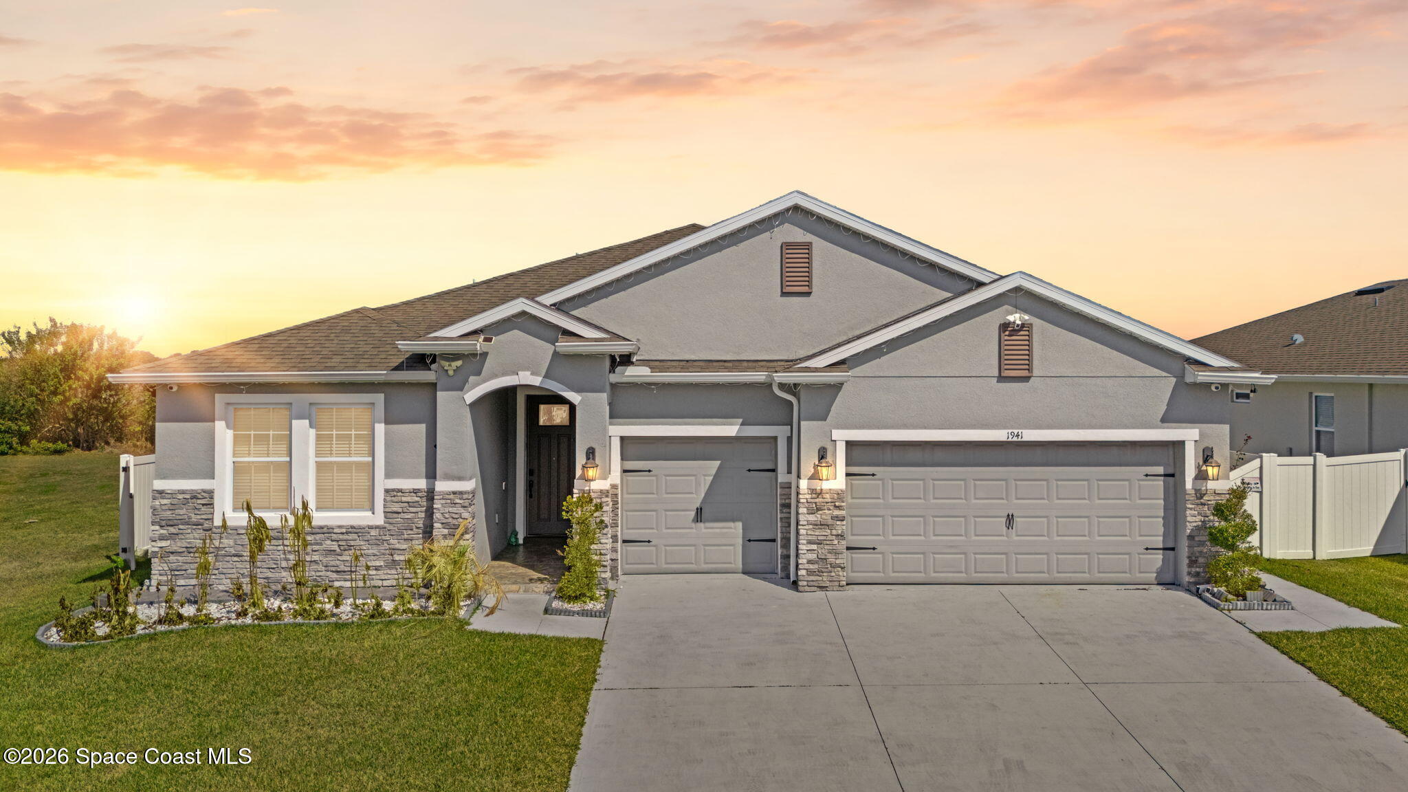 a front view of a house with a garden and yard