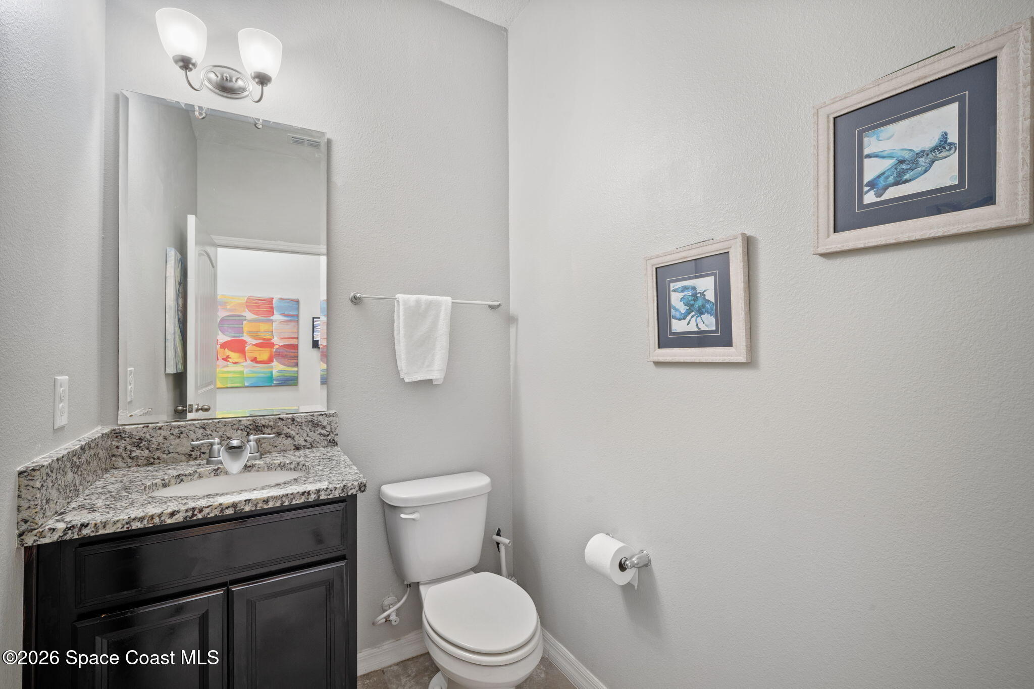 1941 Partin Terrace Road Kissimmee, FL 34744 - Photo 17 of 36 a bathroom with a granite countertop toilet sink and mirror