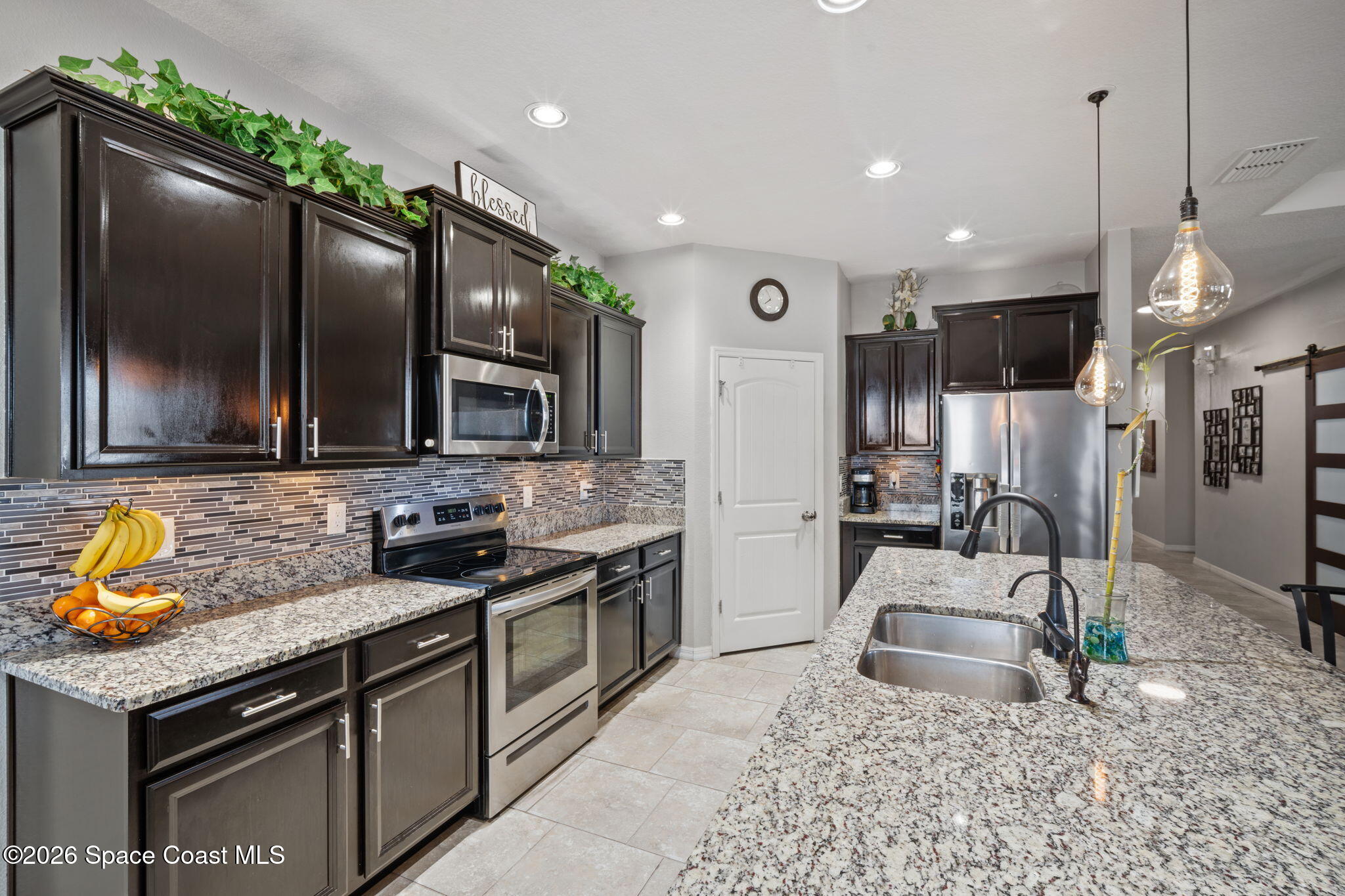 1941 Partin Terrace Road Kissimmee, FL 34744 - Photo 4 of 36 a kitchen with stainless steel appliances granite countertop a sink stove and refrigerator