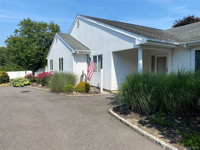 a view of a house with a yard and potted plants