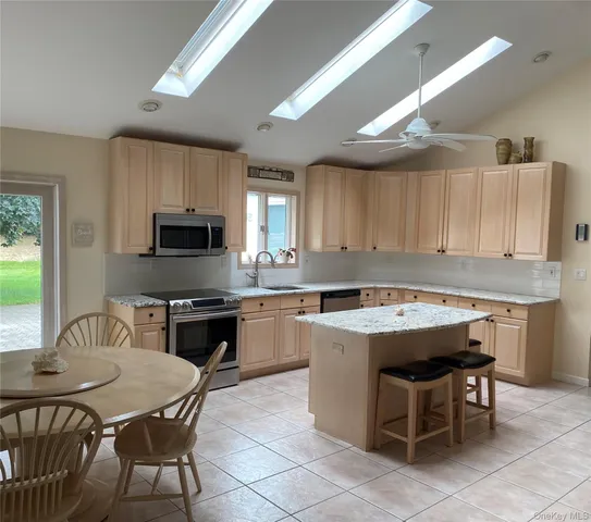 a kitchen with a table chairs microwave and cabinets