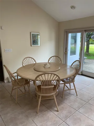 a view of a dining room and livingroom with furniture wooden floor and a rug