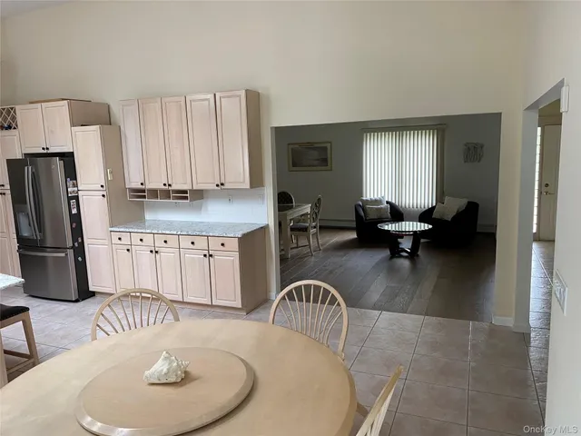 a kitchen with granite countertop a table chairs stove a refrigerator and couch