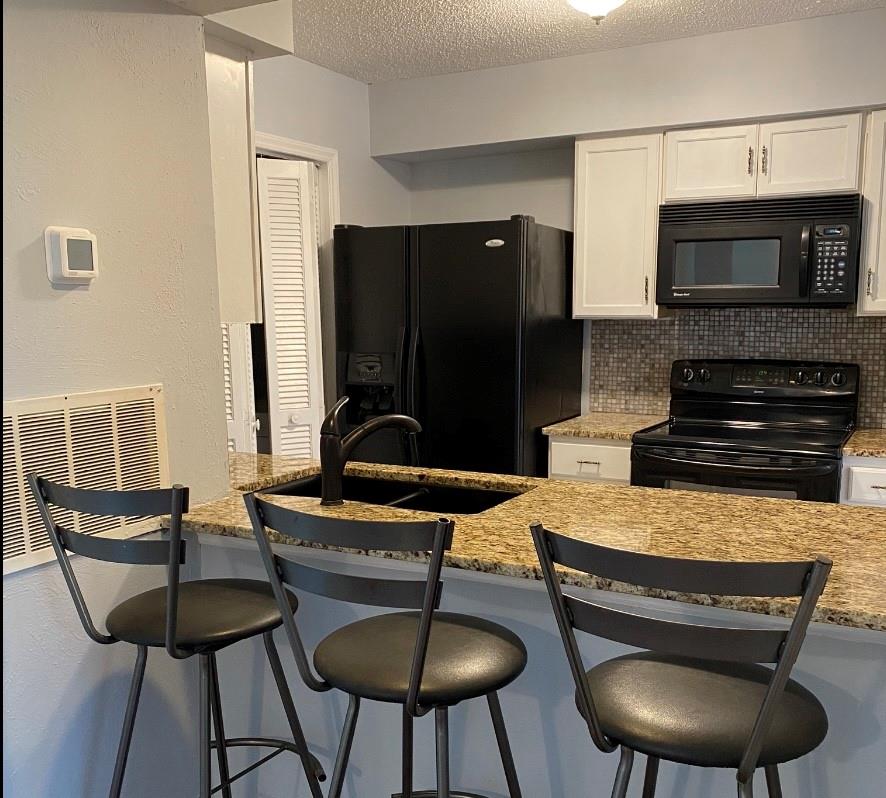 11111 Harrowfield Road Charlotte, NC 28226 - Photo 4 of 26 a kitchen with stainless steel appliances granite countertop a stove top oven a sink a dining table and chairs
