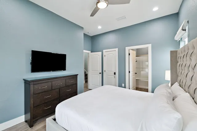 a bedroom with a bed a couch and a dresser next to a window