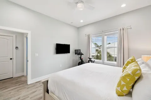 a bedroom with a bed flat screen tv and a chandelier