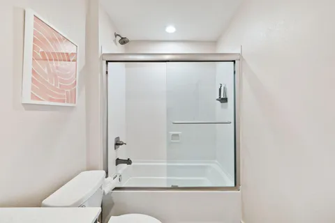 a bathroom with a sink a toilet and shower