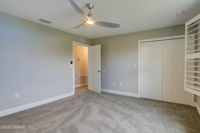 an empty room with closet and windows