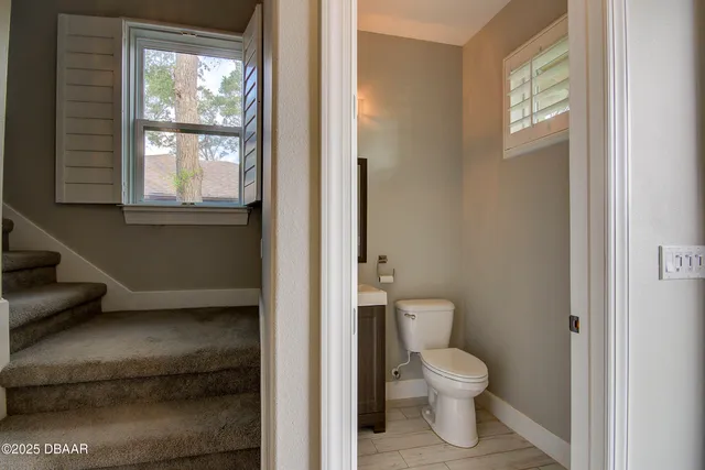 a bathroom with a toilet a sink and a window