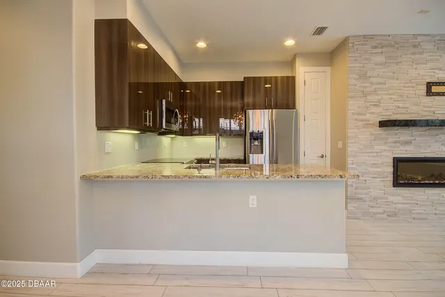 a view of kitchen with stainless steel appliances granite countertop sink