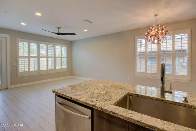 a kitchen with granite countertop sink and natural light