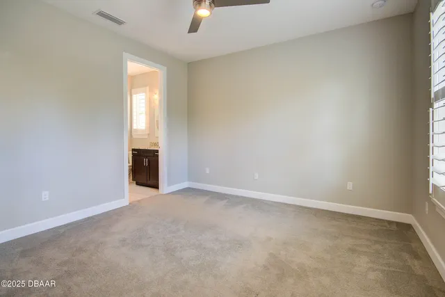 an empty room with chandelier fan