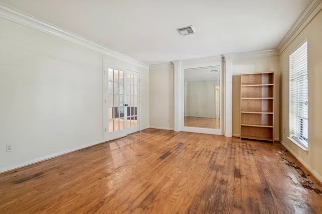a view of empty room with wooden floor and window