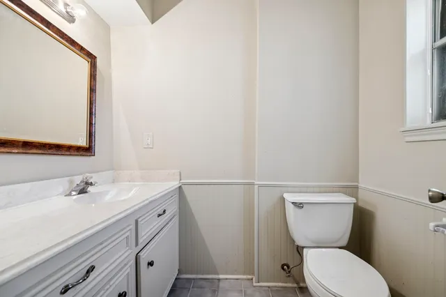 a bathroom with a toilet sink and mirror