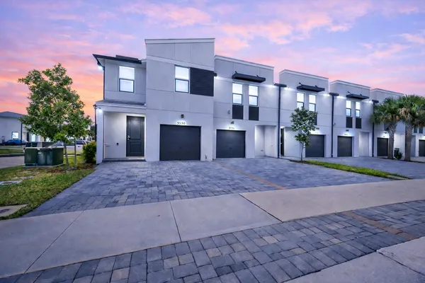 a view of a house with a yard and a garage