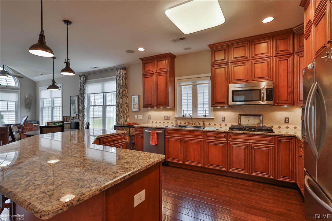 1035 Declaration Drive Bethlehem, PA 18017 - Photo 12 of 38 a kitchen with stainless steel appliances granite countertop wooden cabinets a stove a sink a dining table and chairs