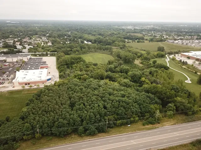 an aerial view of residential houses with outdoor space and trees