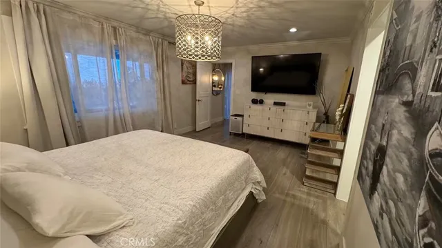 a bedroom with a bed and a flat tv screen on wall