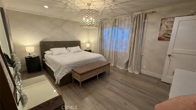 a bedroom with a bed and a large mirror with wooden floor