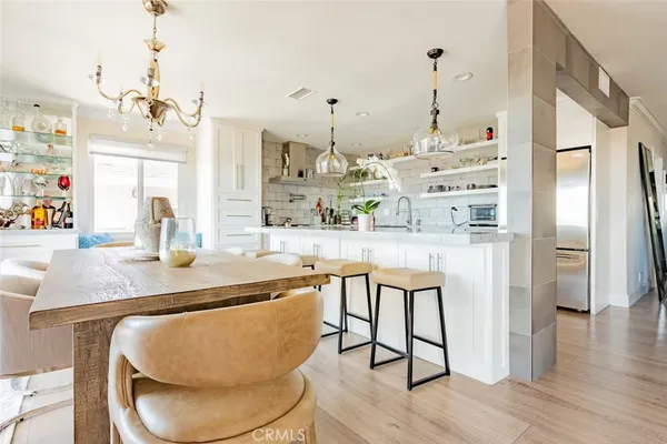 a dining table chairs and chandelier in a kitchen