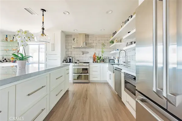 a kitchen with white cabinets and stainless steel appliances