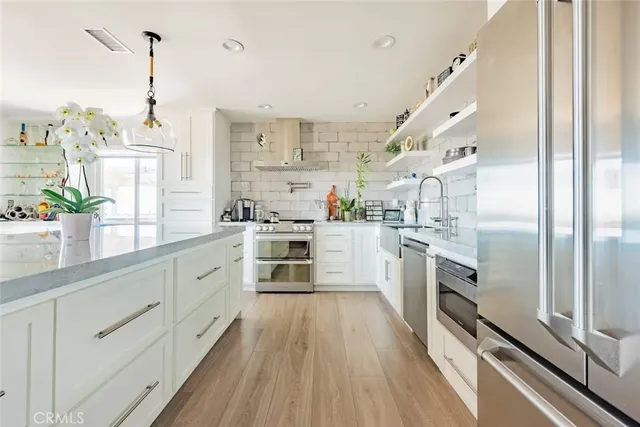 a kitchen with white cabinets and stainless steel appliances