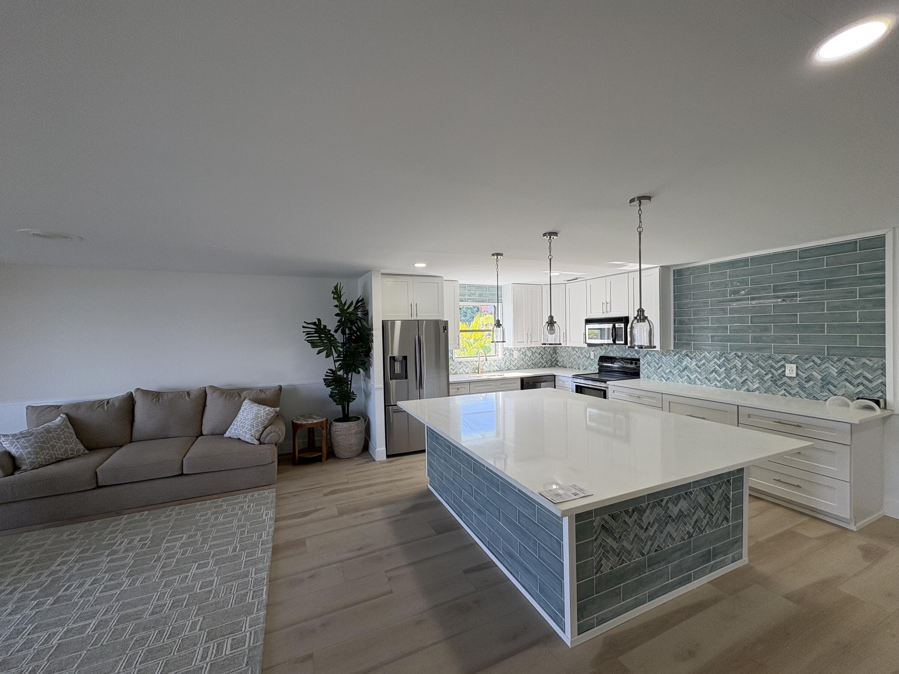 360 Wilma Circle, Unit 7 Riviera Beach, FL 33404 - Photo 14 of 15 a living room with stainless steel appliances kitchen island granite countertop furniture and a fireplace