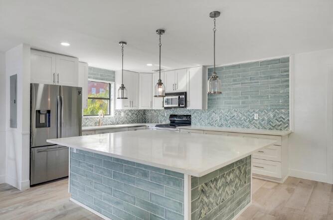 360 Wilma Circle, Unit 7 Riviera Beach, FL 33404 - Photo 5 of 15 a view of a kitchen with kitchen island a counter top space cabinets stainless steel appliances and a counter space