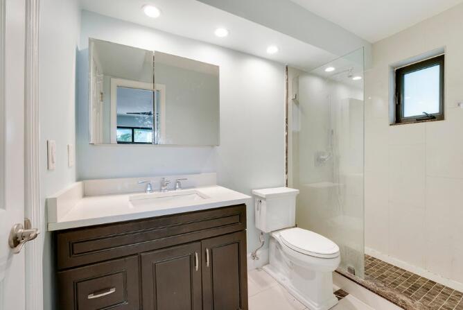 360 Wilma Circle, Unit 7 Riviera Beach, FL 33404 - Photo 9 of 15 a bathroom with a sink a toilet a mirror and shower