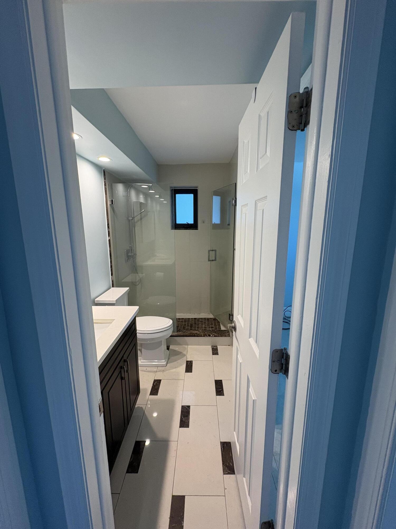 360 Wilma Circle, Unit 7 Riviera Beach, FL 33404 - Photo 10 of 15 a bathroom with a sink a toilet a mirror and shower