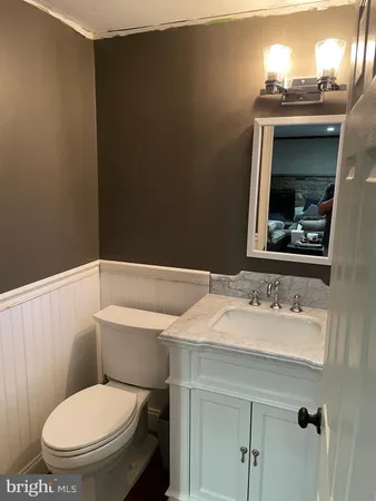 a bathroom with a toilet a sink and mirror