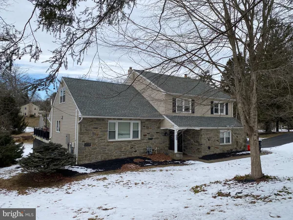 a front view of a house with a yard covered with snow