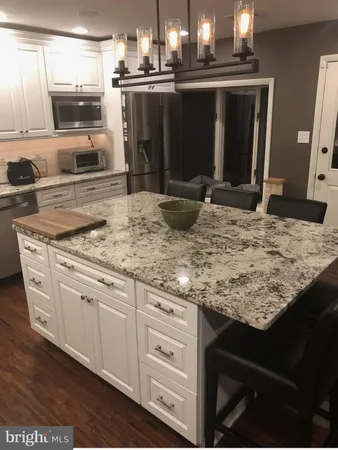 a kitchen with kitchen island granite countertop a sink and stove