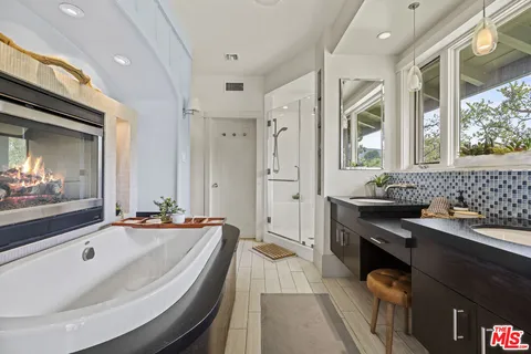 a bathroom with a tub sink and mirror