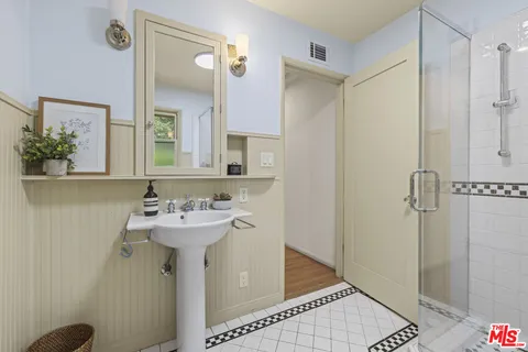 a bathroom with a sink a mirror and shower