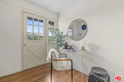 a room with chandelier fan and wooden floor