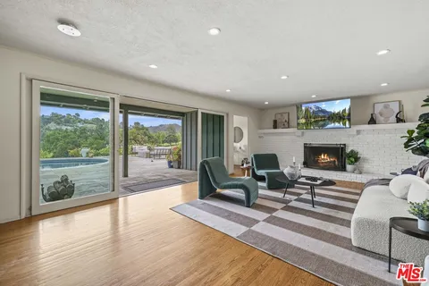 a living room with furniture large windows and a fireplace