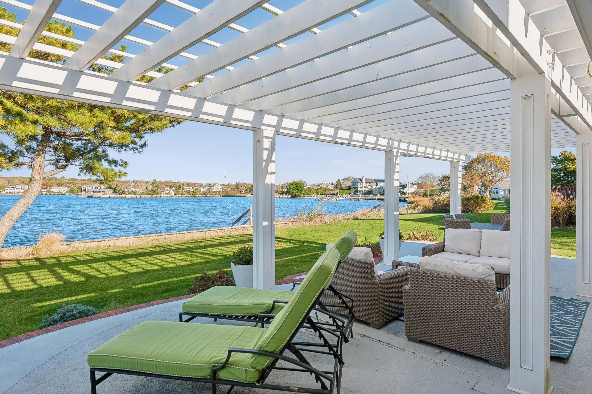 135 Little Neck Road Southampton, NY 11968 - Photo 7 of 20 a view of a patio with lawn chairs next to a yard