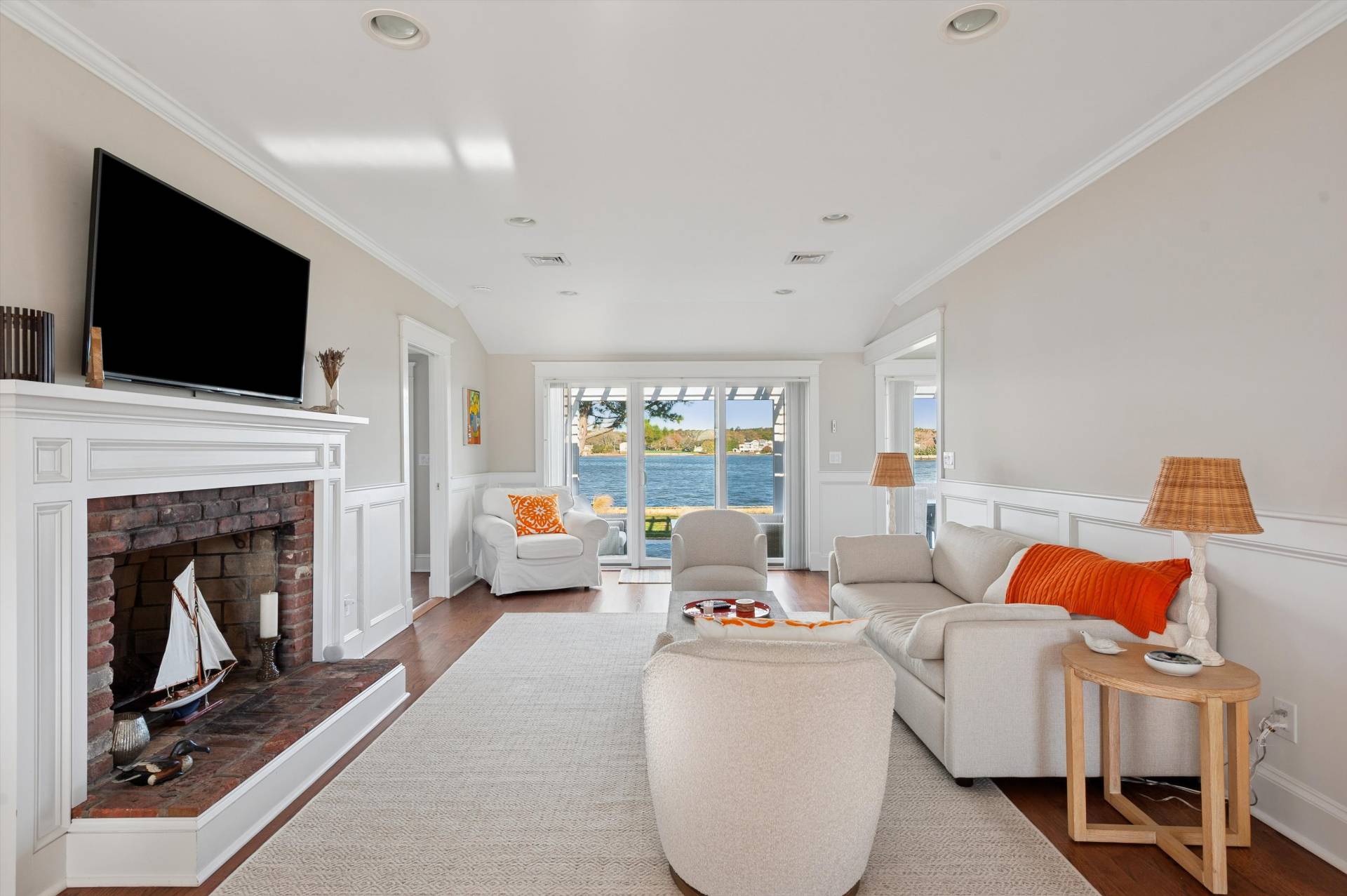 135 Little Neck Road Southampton, NY 11968 - Photo 8 of 20 a living room with furniture a fireplace and a flat screen tv