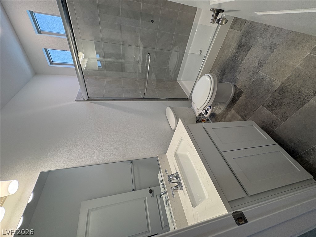 8677 South Indigo Springs Road Las Vegas, NV 89139 - Photo 3 of 9 A well-appointed bathroom features a contemporary vanity, skylights, and a spacious glass-enclosed shower.