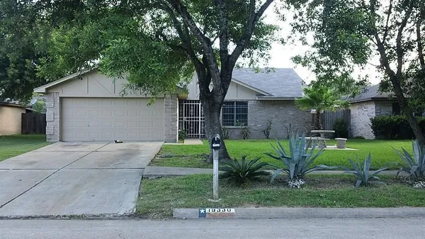 a view of a house with backyard and a tree