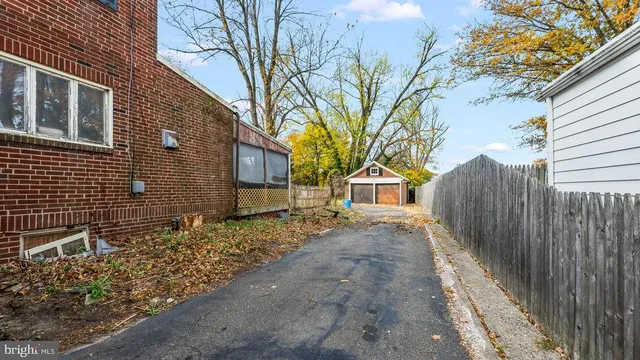 a view of a house with wooden fence next to a road