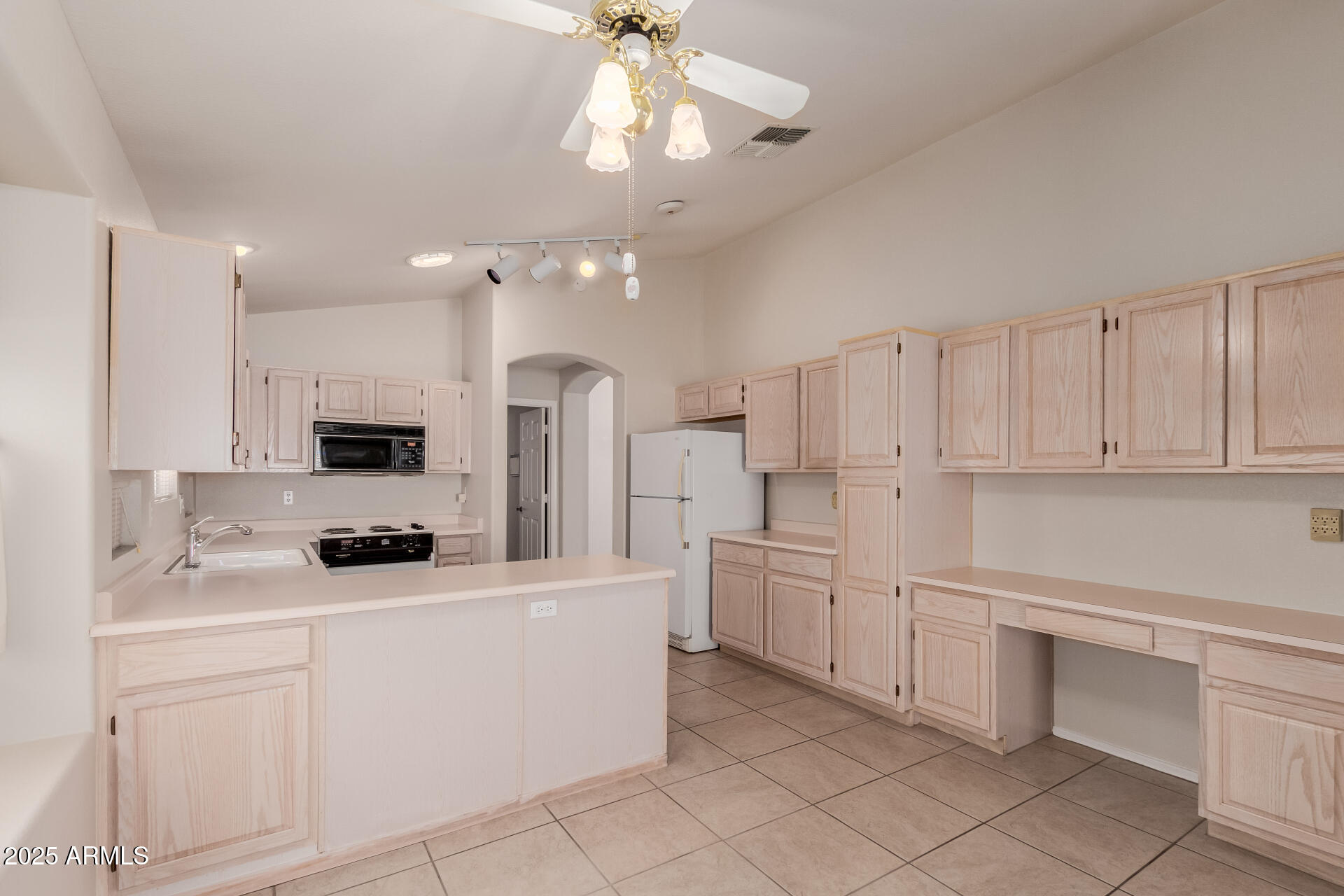 14588 West Bison Path Surprise, AZ 85374 - Photo 17 of 42 a kitchen with white cabinets and stainless steel appliances