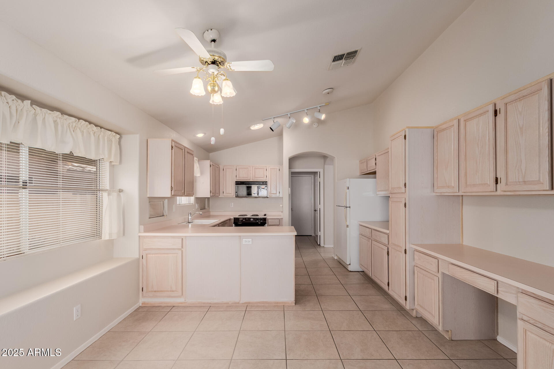 14588 West Bison Path Surprise, AZ 85374 - Photo 18 of 42 a large white kitchen with a large window cabinets and stainless steel appliances