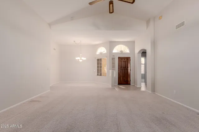 a view of a room with chandelier fan and windows