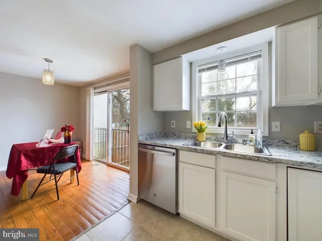 a kitchen with granite countertop a sink cabinets and wooden floor