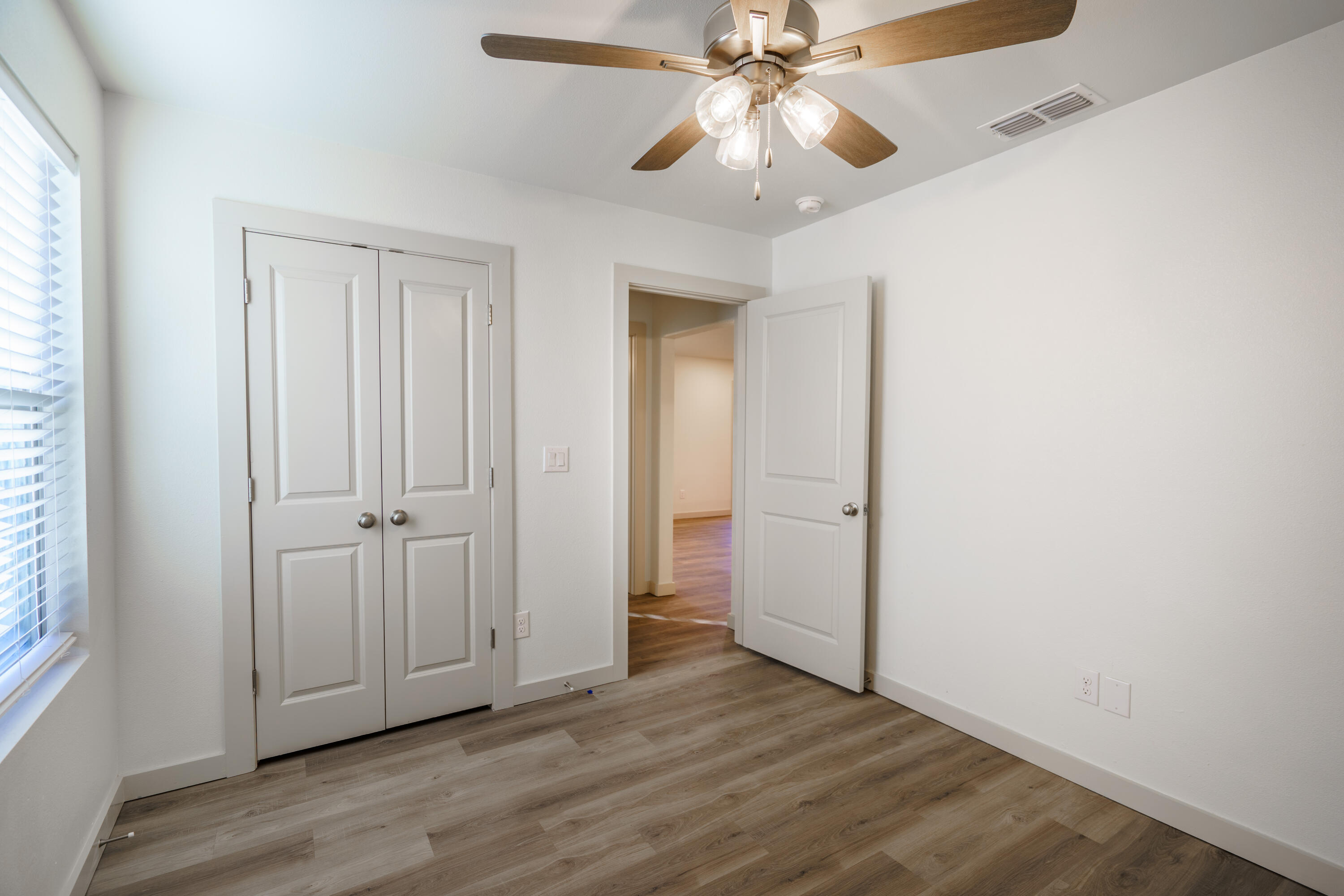 320 East 76th Street Lubbock, TX 79404 - Photo 6 of 14 an empty room with wooden floor closet and windows