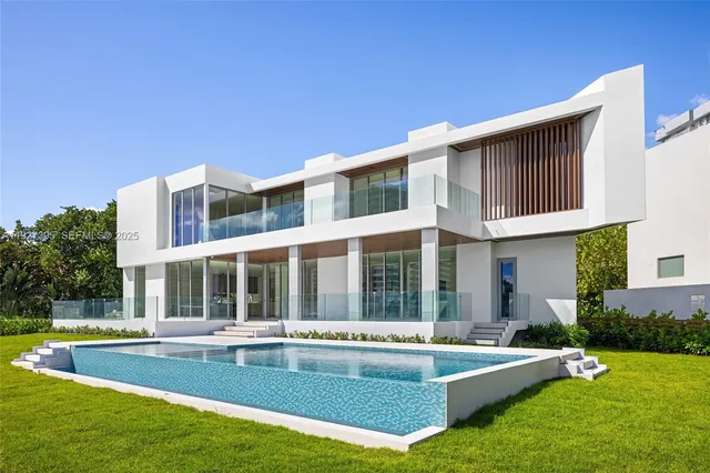a view of a house with a backyard patio and swimming pool